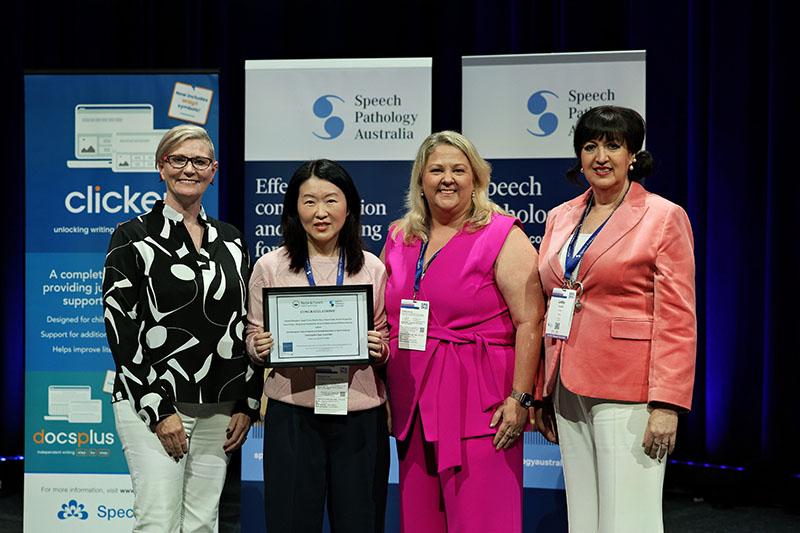 This is a photo of Angel Chan holding an IJSLP Editor’s Award plaque as she poses with Emma Power, Natalie Munro and Professor Elizabeth Cardell at the SPA 2026 Conference. 