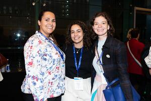 Three attendees smiling at the camera.