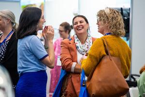 Attendees chatting in the exhibition hall.