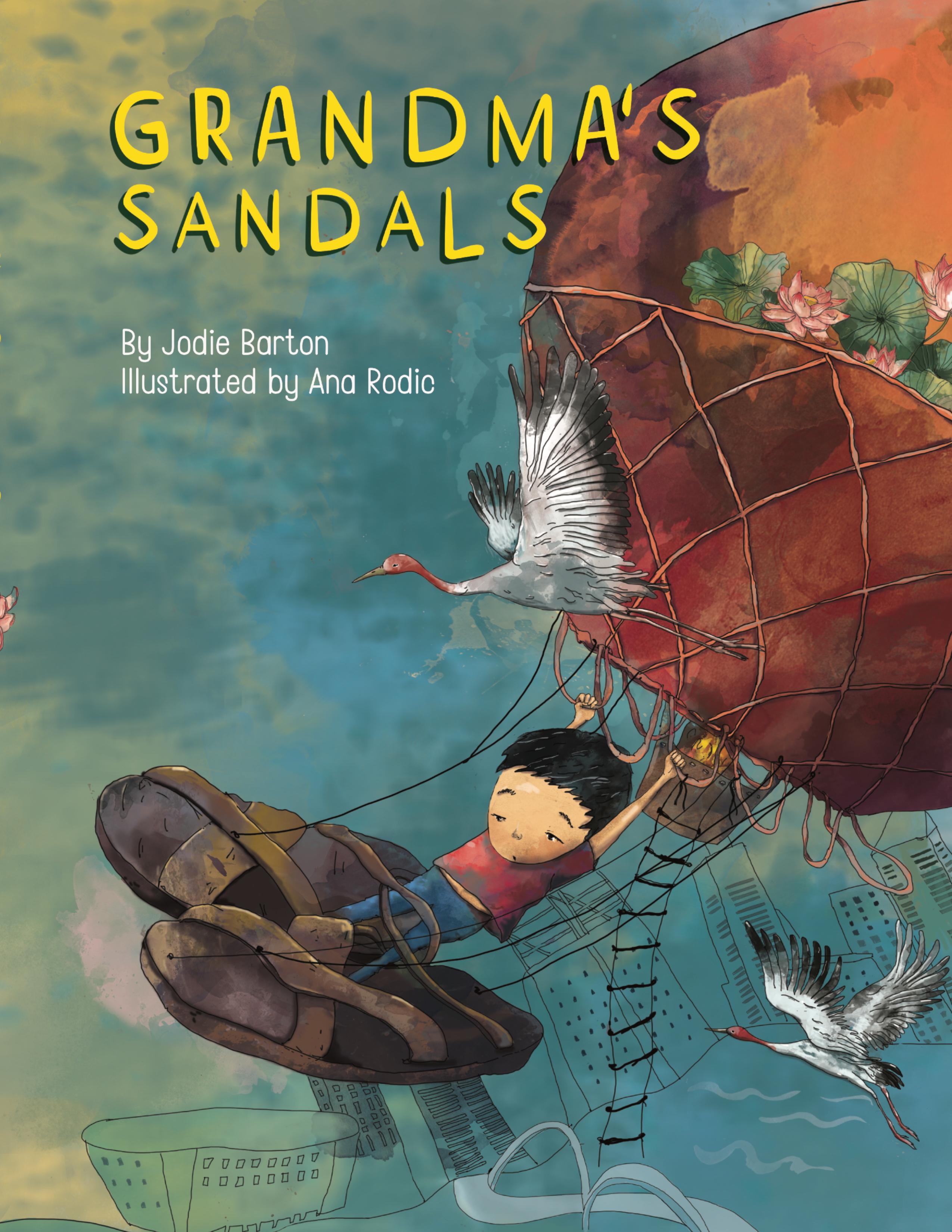 This is the cover for ‘Grandma's Sandals’ Written by Jodie Barton and illustrated by Ana Rodic. The cover shows a boy wearing very large sandals, the size of his body, as he hangs onto a hot air balloon in the sky.